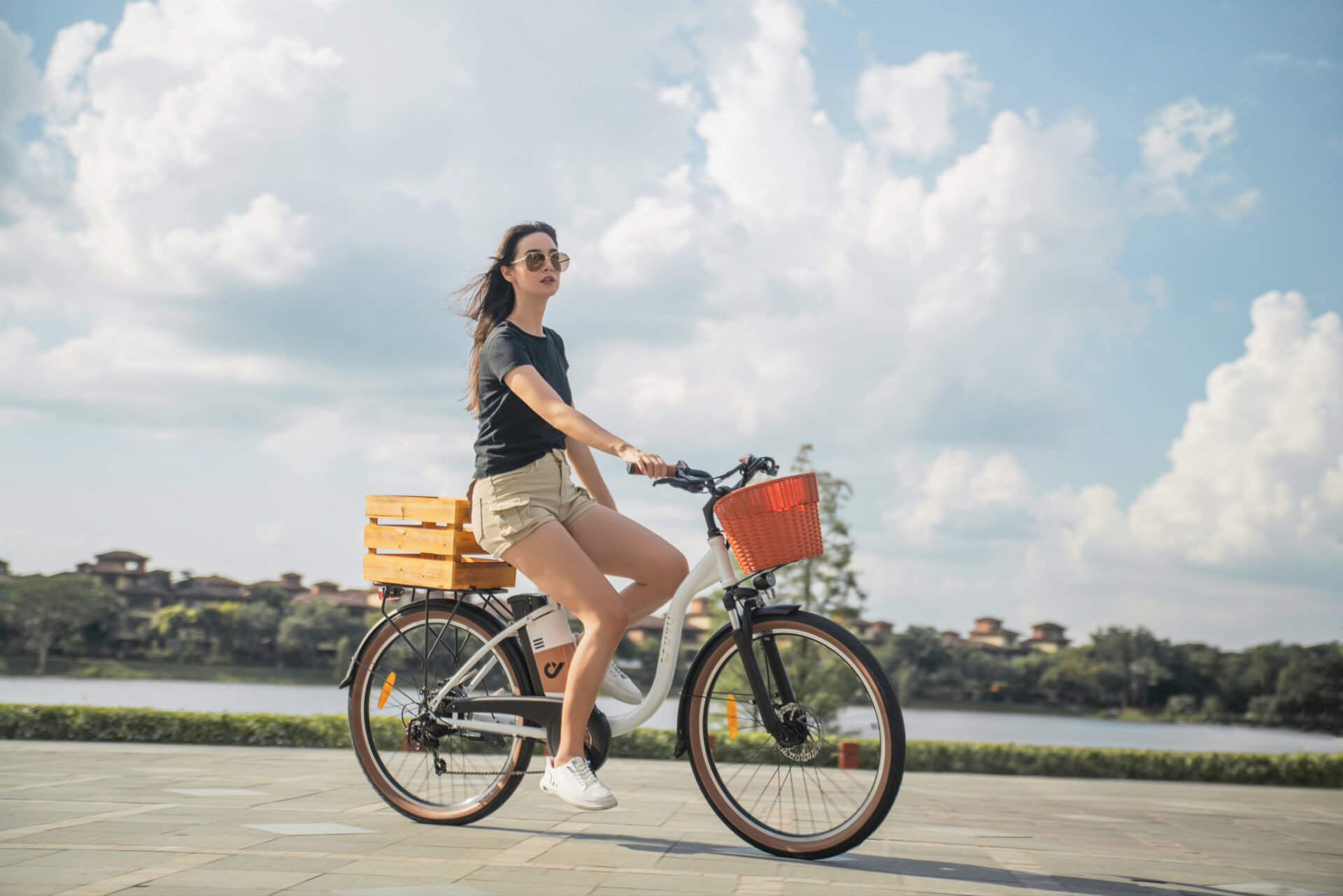Person riding an electric bike through a scenic path, surrounded by greenery and sunlight