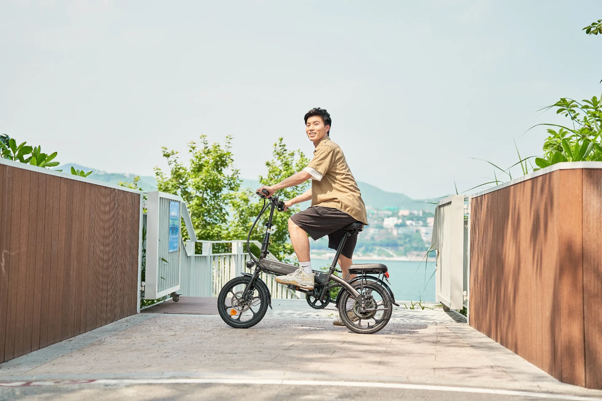 DYU A1F Pro folding e-bike riding on a terrace with ocean backdrop