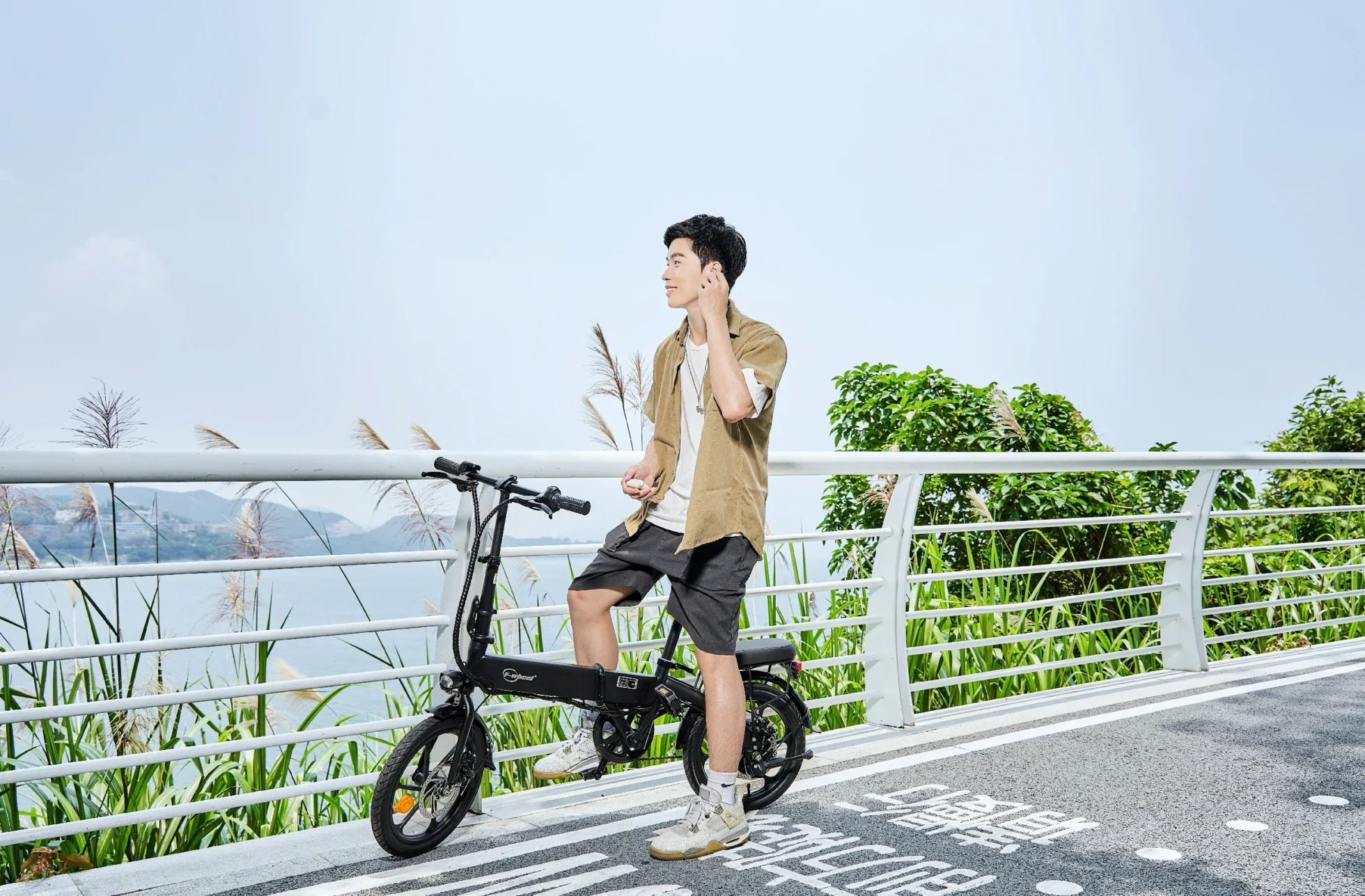 Bicicleta eléctrica DYU A1F Pro con cesta delantera y portaequipajes trasero en una carretera costera