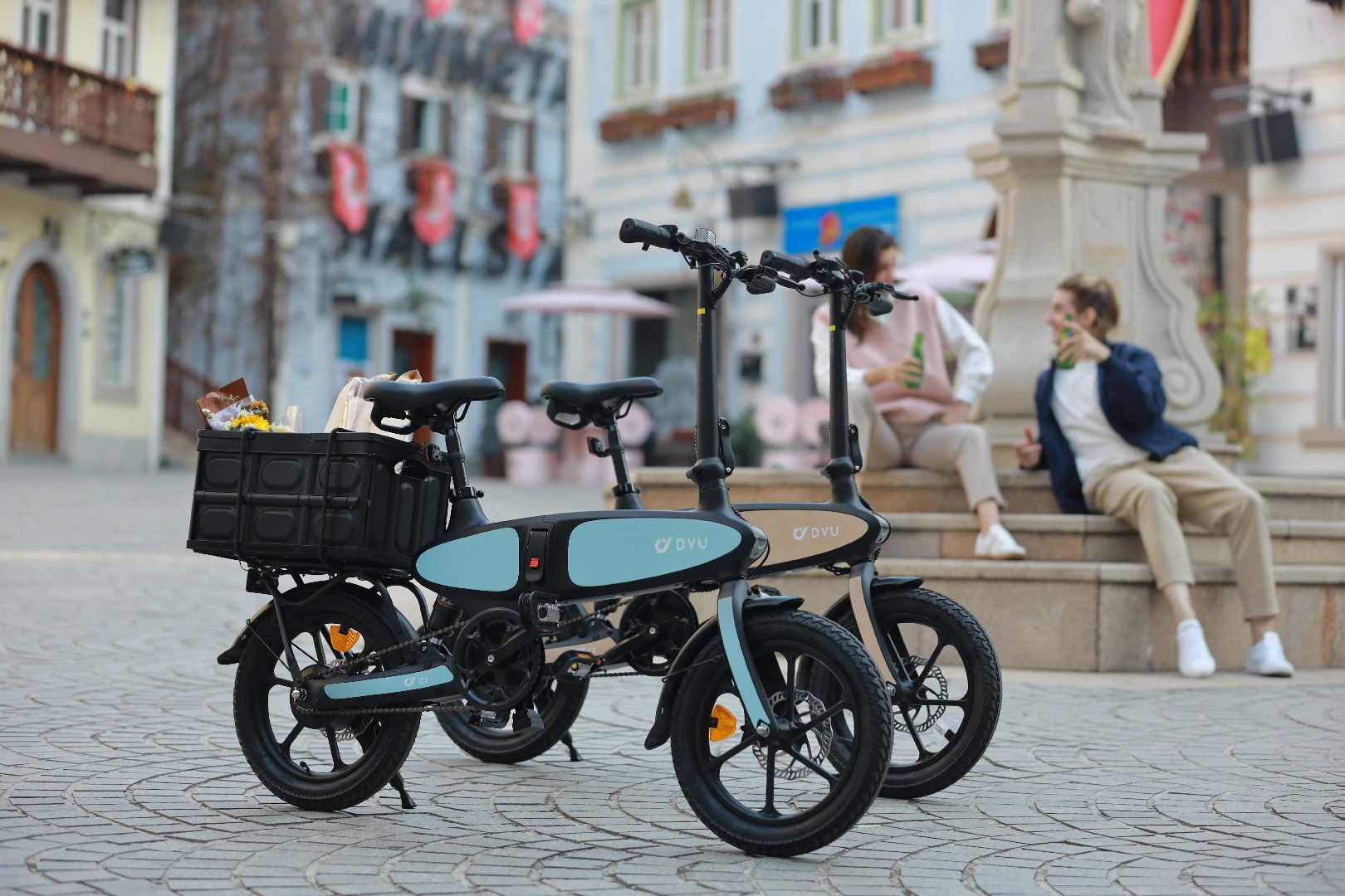 Bicicleta elétrica dobrável DYU C2 estacionada em uma praça mostrando tamanho de armazenamento compacto