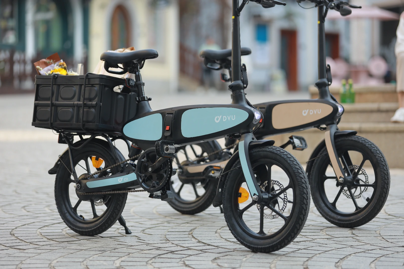 DYU C2 folding e-bikes parked by city plaza architecture