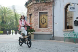 DYU C2 woman riding past brick buildings in a European city