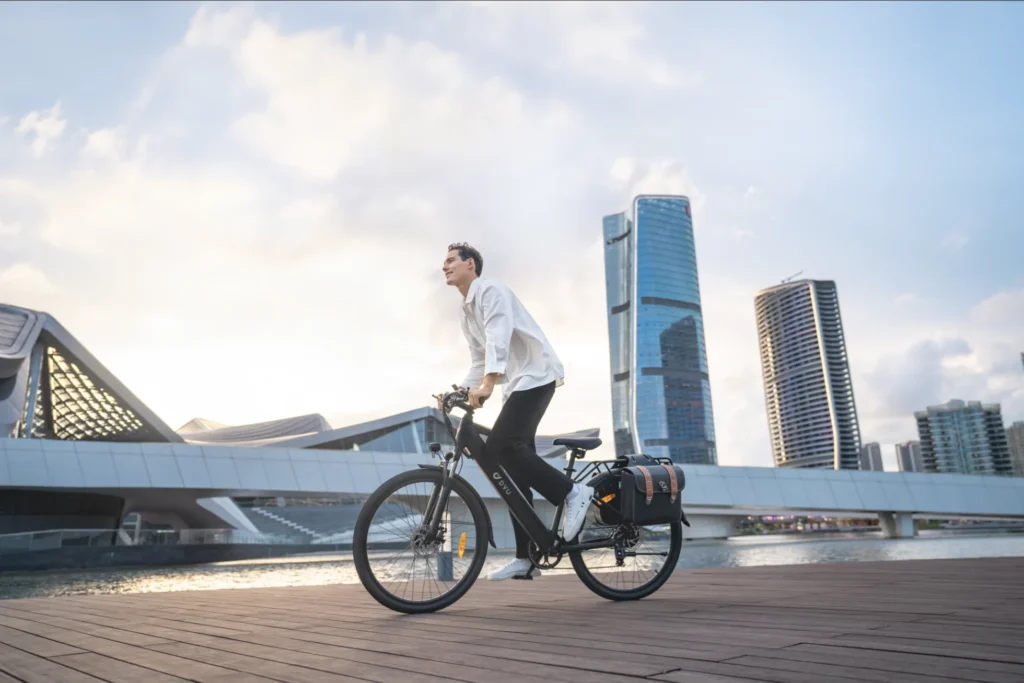 DYU C5 27.5-inch city e-bike riding along a waterfront path