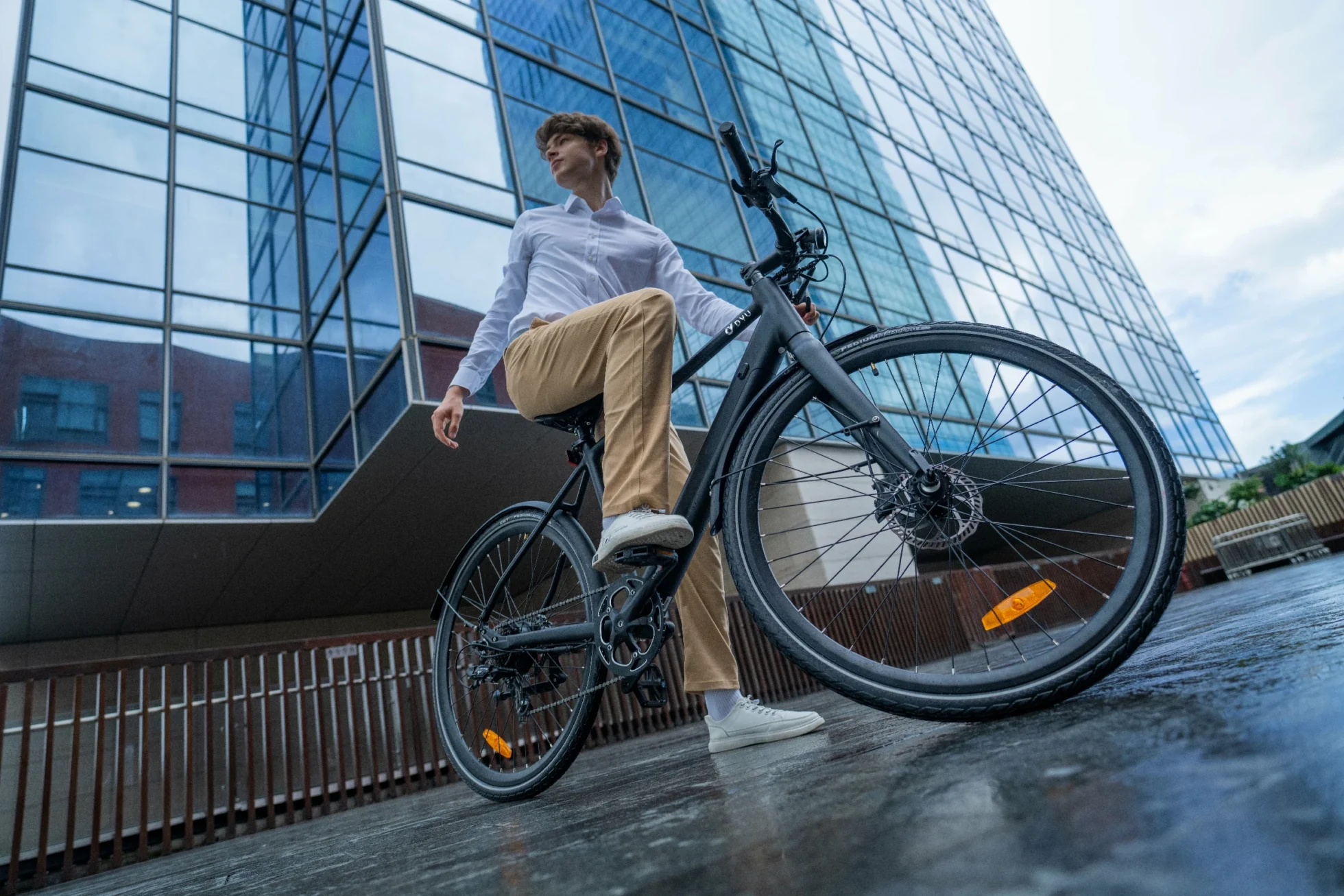 DYU Stroll 1 rider lifting the front wheel near urban architecture