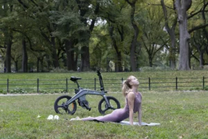 DYU T1 rider stretching beside a foldable e-bike in a park